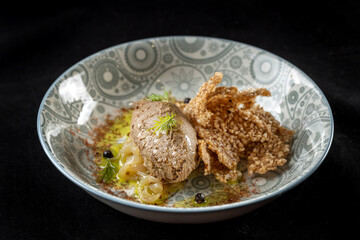Goose liver pate on a plate of breads. With fried onions, on a beautiful plate.