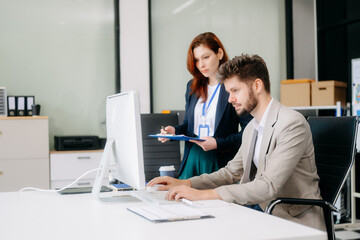 Obraz premium Two busy happy professional business man and woman executive leaders team using laptop working