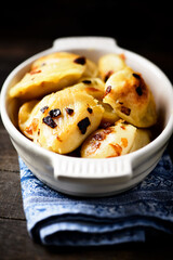 Dumplings with potato and cottage cheese stuffing (pierogi). Wooden background. Copy space.