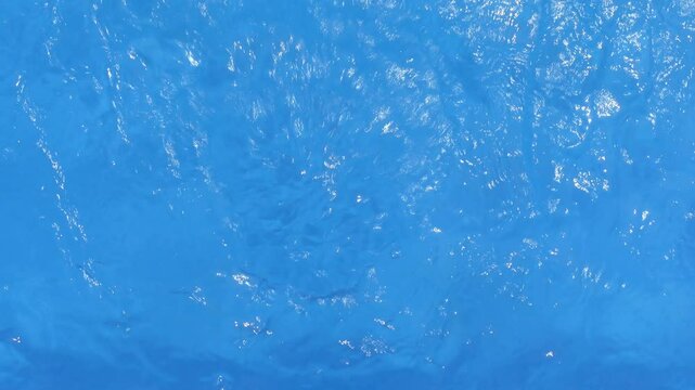 Movement of water on the surface of a pool by the effect of the ejector jet with waves that reflect sunlight
