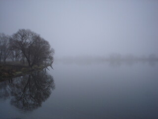 Bad weather. Fog and cold near the river Gloomy landscape