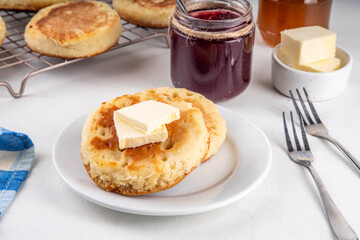 Traditional English skillet fried breakfast pastry Crumpets, popular in England, Britain pancakes. Sweet hot crumpets stack with melting butter and jam