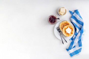 Traditional English skillet fried breakfast pastry Crumpets, popular in England, Britain pancakes. Sweet hot crumpets stack with melting butter and jam