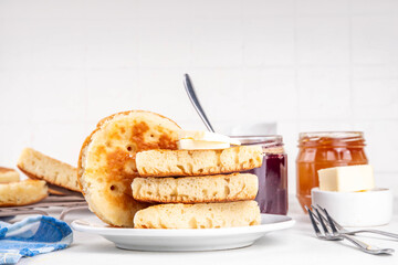 Traditional English skillet fried breakfast pastry Crumpets, popular in England, Britain pancakes. Sweet hot crumpets stack with melting butter and jam