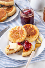 Traditional English skillet fried breakfast pastry Crumpets, popular in England, Britain pancakes. Sweet hot crumpets stack with melting butter and jam
