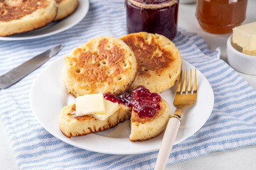 Traditional English skillet fried breakfast pastry Crumpets, popular in England, Britain pancakes. Sweet hot crumpets stack with melting butter and jam