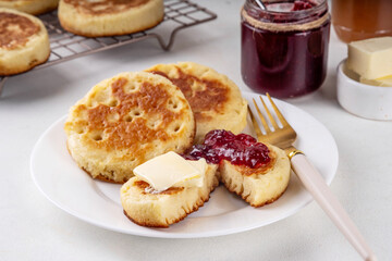 Traditional English skillet fried breakfast pastry Crumpets, popular in England, Britain pancakes. Sweet hot crumpets stack with melting butter and jam
