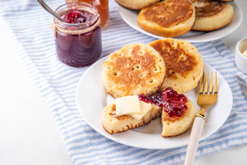 Traditional English skillet fried breakfast pastry Crumpets, popular in England, Britain pancakes. Sweet hot crumpets stack with melting butter and jam