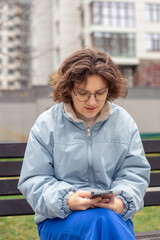 Fototapeta premium Teenage girl with a phone. Teenage girl in the city. Life in the city.