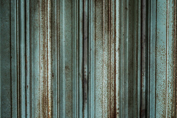 Old broken and rusty green sliding door of an abandoned building.