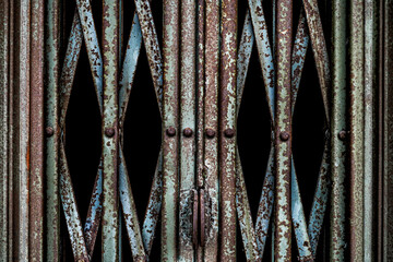 Old broken and rusty green sliding door of an abandoned building.