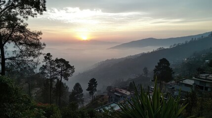 A mountain range with a lush green valley in between. The sky is clear and blue with a few clouds. The mountains are covered in trees and the valley is full of grass.
