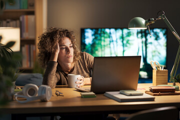 Woman watching videos on her laptop at night