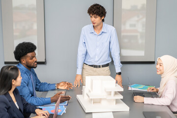 Architects engineers collaborating on building design project in modern office, diverse team of professionals female muslim architect and male engineers discussing architectural model of structure