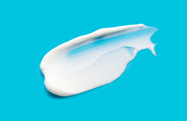 A sample of white cosmetic moisturizer on a blue background