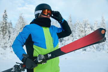 Portrait of a skier in the ski resort on the background of mountains and blue sky, Bukovel. Ski...
