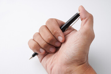 A close-up photo of a man's hand holding a classic pen, writing something on a blank white sheet of paper. Isolated on white background.