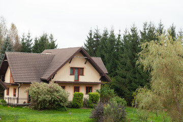 Charming house nestled in a lush green landscape, surrounded by trees. Perfect for a peaceful getaway.