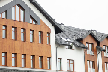 Modern residential buildings with contrasting wood and white siding, showcasing sleek architecture and design.
