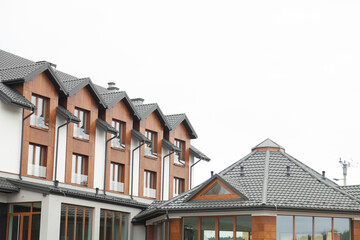 Modern building with gray roofs and brown wood accents. Clean lines and contemporary design.