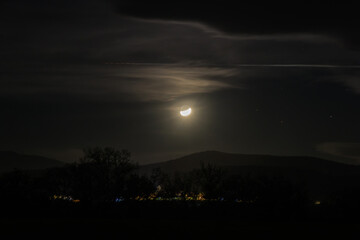clair de lune et train de satellites au dessus d'un village éclairé © Marc