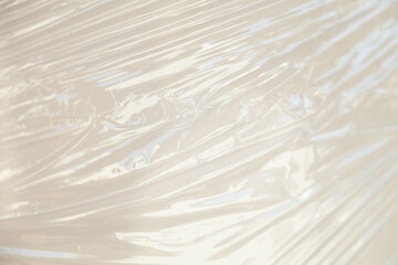 Close-up of translucent plastic wrap, showing its texture and folds.  Ideal for background or...