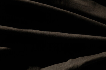 Draped dark fabric texture.  Subtle folds and shadows create a dramatic, moody background.