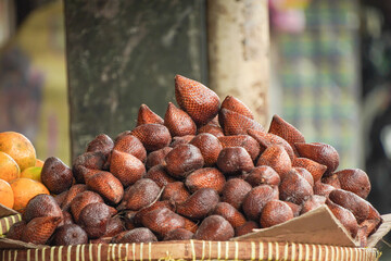 Pile of fresh salak pondoh or snake fruit in Indonesian traditional market. Salacca zalacca fruit.