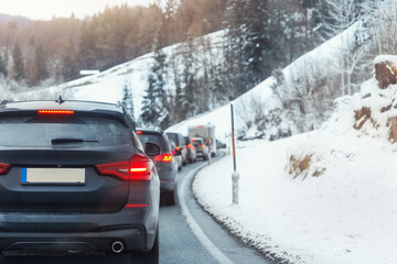 Scenic view many cars stuck row mountain alpine forest road traffic jam cold winter day at Europe mountain resort. Automobile accident vehicle rush hour collapse. Vacation transport seasonal stuck.