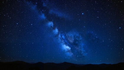 Fototapeta premium Stunning night sky filled with stars and the Milky Way over mountain landscape