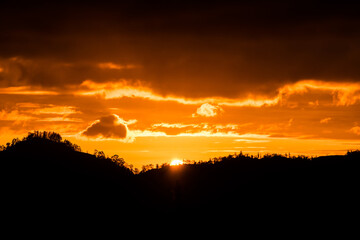 Beautiful sunrise on the island Bali on Batur Vulcano. Silhouettes of palm trees on a background of colored clouds