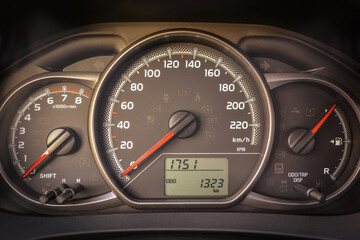 Close up of a car's instrument panel showing speed RPM and odometer readings