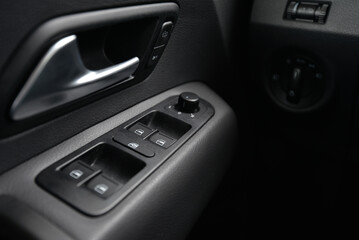 Obraz premium Close up of car door panel with window controls and door handle