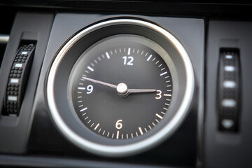 Close up of an analog clock in a vehicle's dashboard