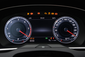 Car dashboard display showing speed RPM and warning lights