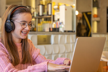 A teenage girl is working on a laptop. Distance education.