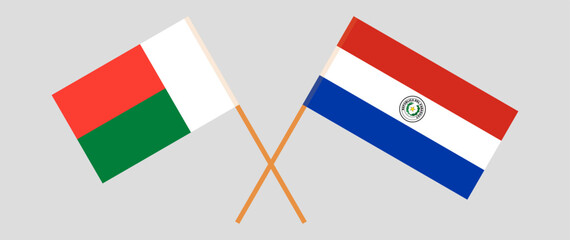 Crossed flags of Madagascar and Republic of Paraguay. Official colors. Correct proportion. Vector illustration