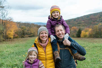 Happy family of four enjoying a colorful autumn day outdoors