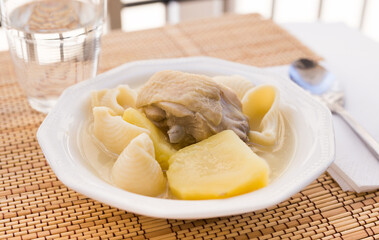Chicken broth soup with chicken, potatoes, and pasta shells