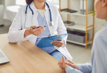 Close up shot of a doctor or nurse hands during a medical consultation and conversation with a...