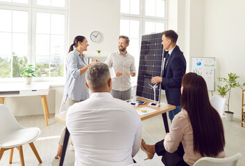 Office team participates in a group presentation focused on solar panels and renewable energy. The...