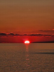 Genova, Italy - December 29, 2024: Background of beautiful sunset over Mediterranean sea waves. Selective focus. Beautiful red and orange sunrise over the sea. Beautiful seascape scenery, Amazing ligh