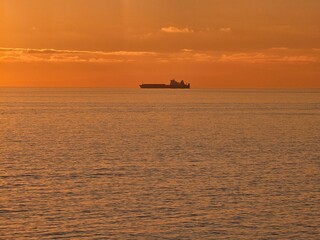 Genova, Italy - December 29, 2024: Background of beautiful sunset over Mediterranean sea waves. Selective focus. Beautiful red and orange sunrise over the sea. Beautiful seascape scenery, Amazing ligh