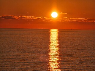Genova, Italy - December 29, 2024: Background of beautiful sunset over Mediterranean sea waves. Selective focus. Beautiful red and orange sunrise over the sea. Beautiful seascape scenery, Amazing ligh