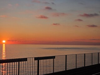 Genova, Italy - December 29, 2024: Background of beautiful sunset over Mediterranean sea waves. Selective focus. Beautiful red and orange sunrise over the sea. Beautiful seascape scenery, Amazing ligh