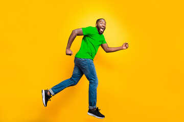 Full length body size photo of casual running man who aspires to achieve what he has planned while isolated with yellow background