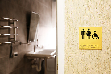 Sign of inclusive bathrooms. Accessible restroom sign directing visitors to facilities for...