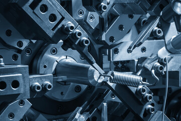 Close up scene operation of the coil spring making machine.