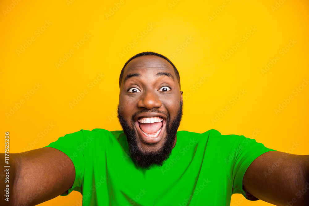 Poster self portrait of rejoicing overjoyed black man playing new camera with face delighted while isolated