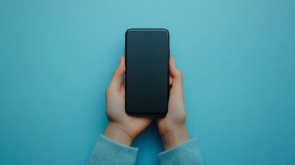 Hands holding a smartphone with blank screen against a solid light blue background symbolizing digital connection and modern communication